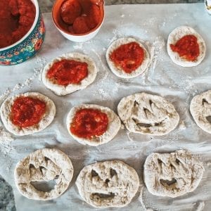 adding pizza sauce to calzones