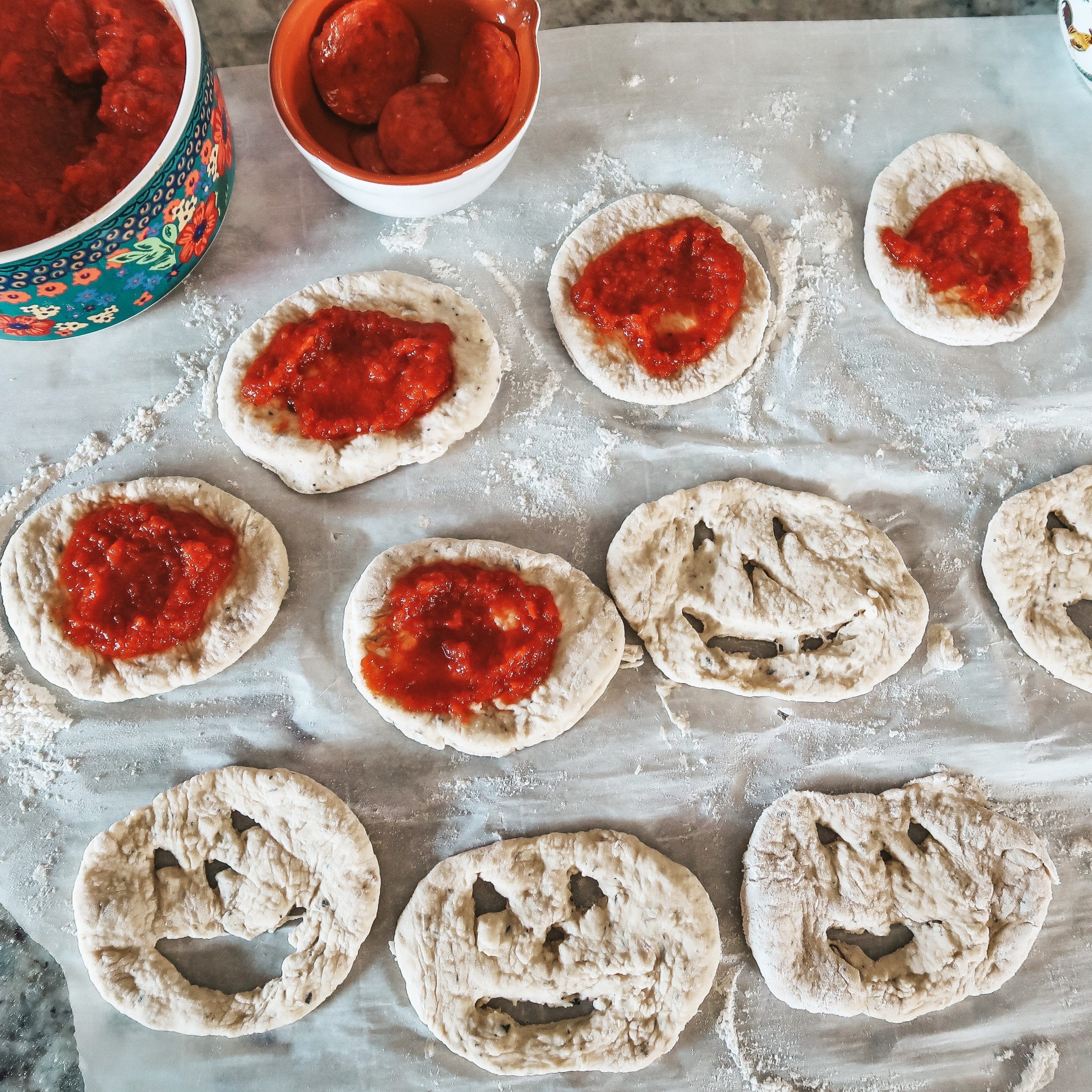 adding pizza sauce to calzones