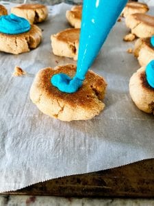 Adding buttercream frosting to cookies