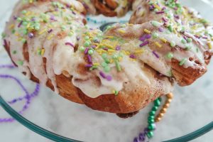 adding the sprinkles to the king cake