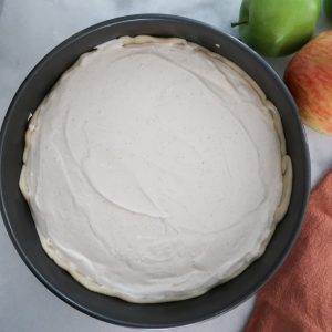 adding cheesecake batter on top of the pie crust