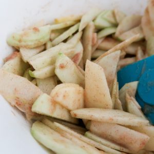 mixing up the apple slices, sugar and cinnamon