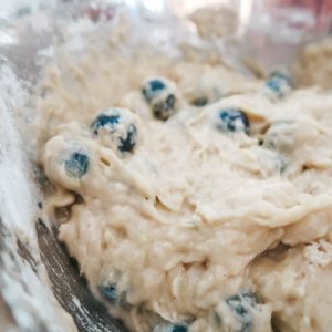 adding the blueberries to the lemon zucchini cake batter