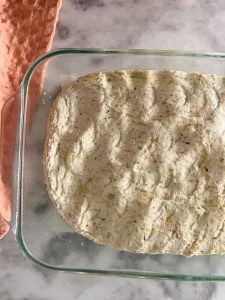 pressing focaccia dough into the 9 x 13 pan