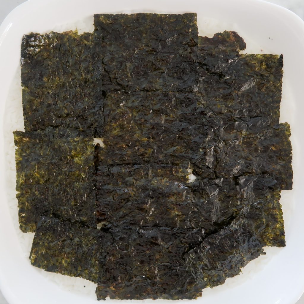 seaweed sheets layered on top of sushi rice layer
