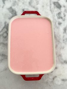 adding the strawberry layer to the dessert lasagna