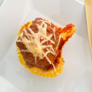 meatball pie cups with shredded parmesan and mozarella cheese on top